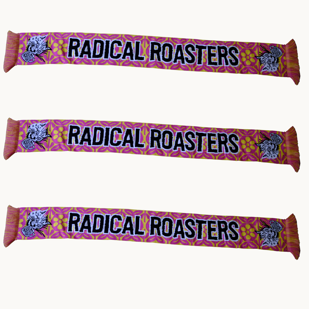 Three identical scarves are shown horizontally on a plain light background. Each scarf has a pink and orange floral pattern, the text 'RADICAL ROASTERS' in black with a white outline, and a stylized rooster illustration on both ends.