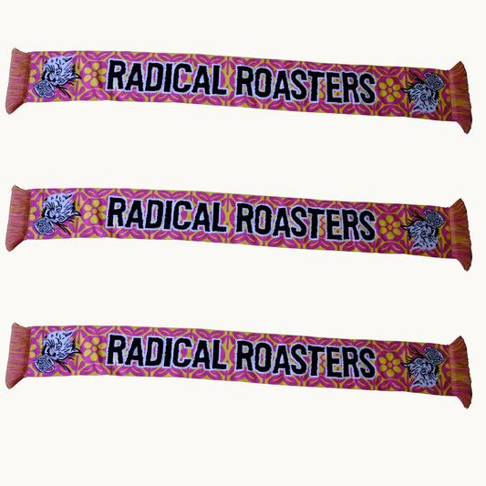 Three identical scarves are shown horizontally on a plain light background. Each scarf has a pink and orange floral pattern, the text 'RADICAL ROASTERS' in black with a white outline, and a stylized rooster illustration on both ends.